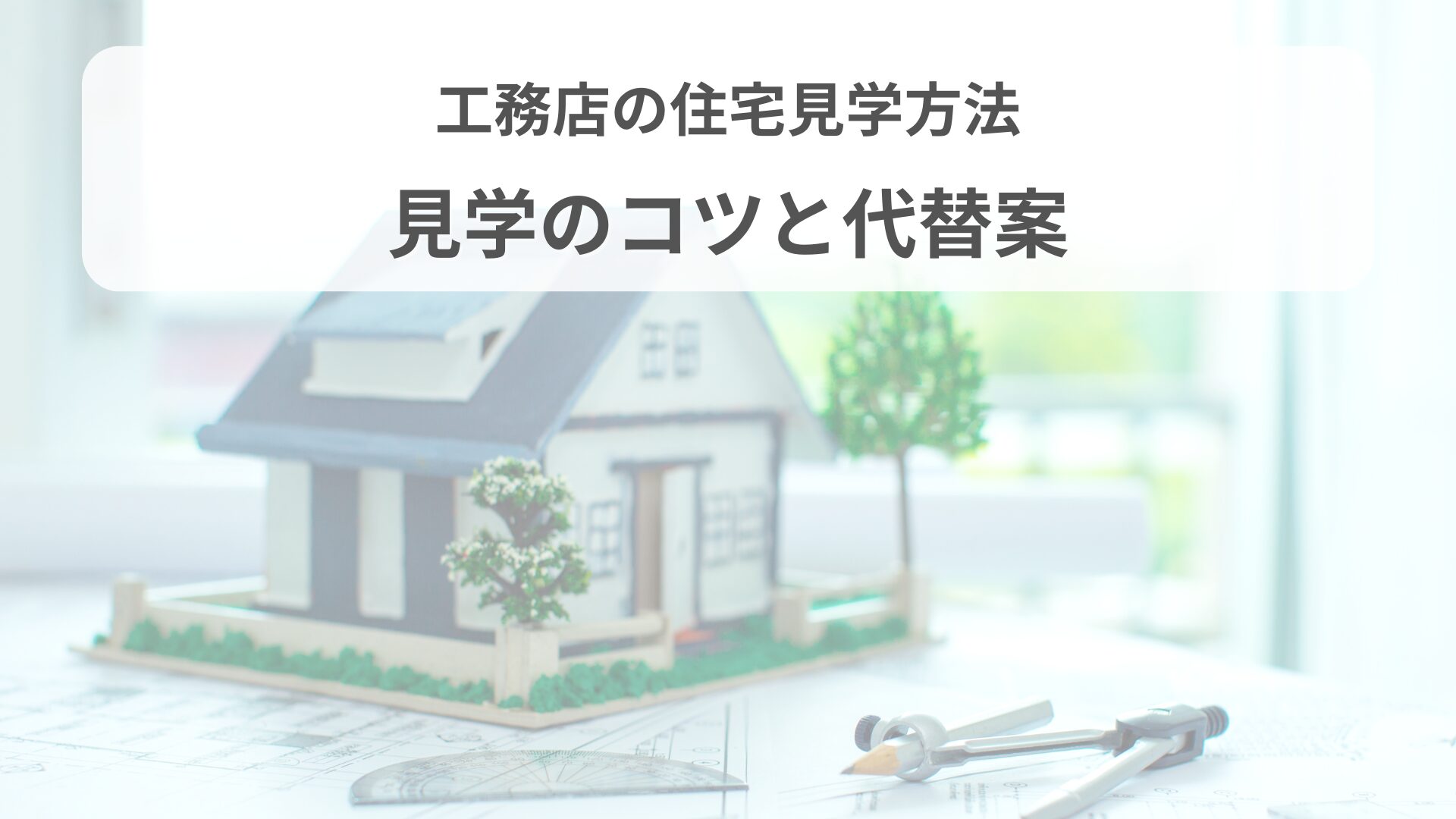 模型の家と製図用コンパス、設計図が置かれた住宅見学のイメージ。明るい窓際のシーン。